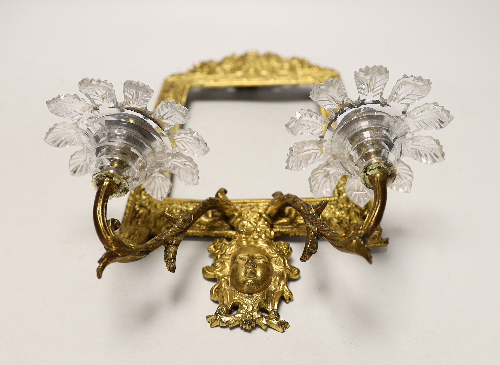 A decorative two branch ormolu wall mirror, lacking the mirror inset. 39cm tall overall, 16.5 x 11.5cm